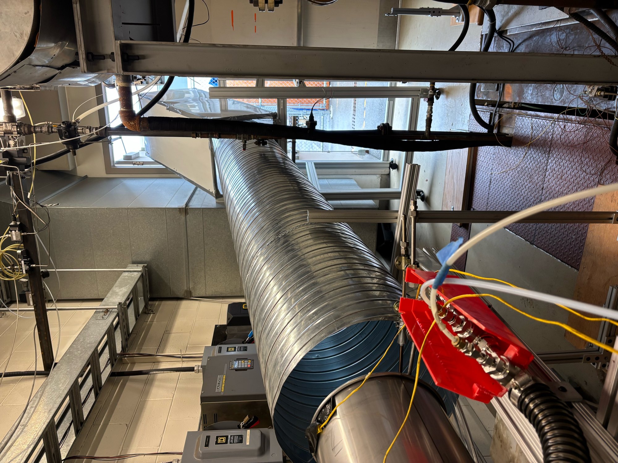 View down the installed exhaust duct from the engine nozzle, with the sampling-probe holder in the foreground